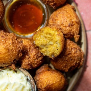 a platter of hush puppies with whipped butter and hot honey