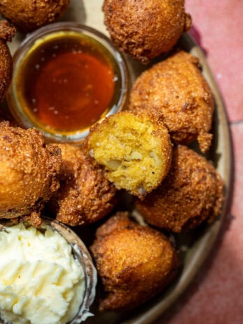 a platter of hush puppies with whipped butter and hot honey