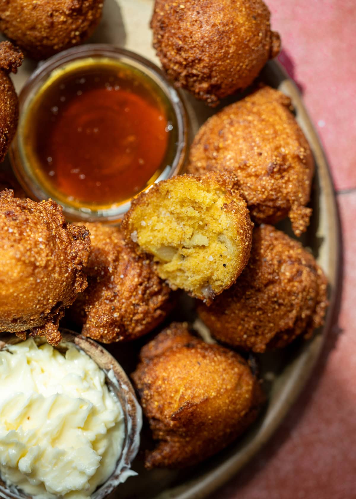 a platter of hush puppies with whipped butter and hot honey