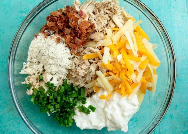 shredded chicken, cheddar cheese, blended cottage cheese, green onions, ranch seasoning, and crispy bacon in a bowl