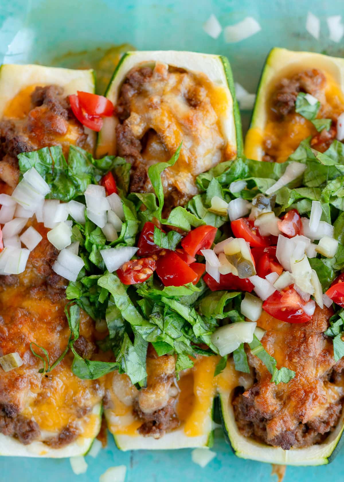 stuffed zucchini boat with cheeseburger filling and toppings