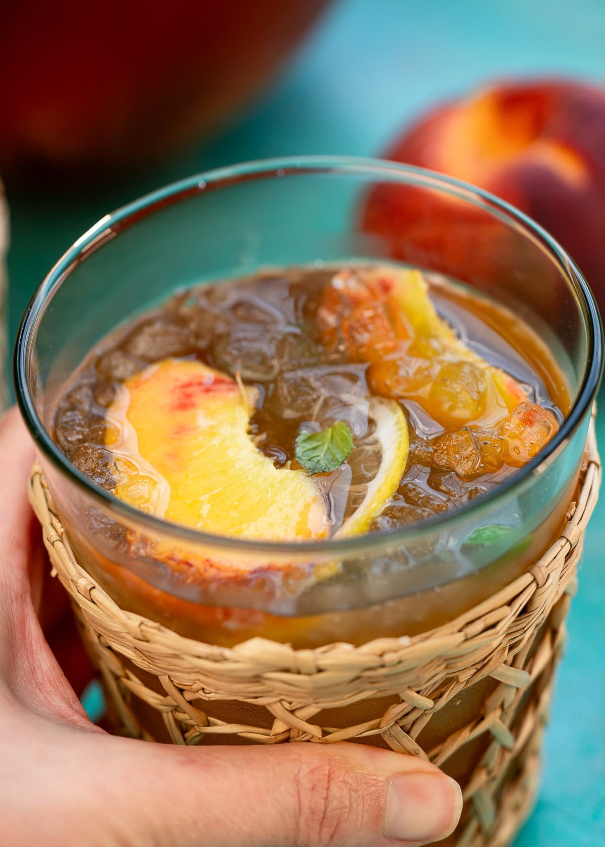 closeup look at peaches floating in a homemade peach tea recipe