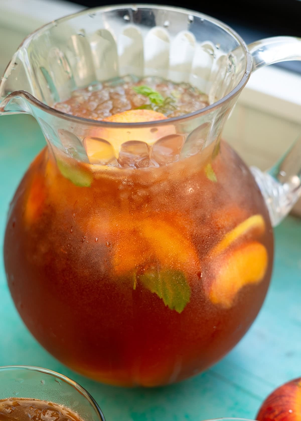 a large pitcher of peach tea made with homemade peach syrup