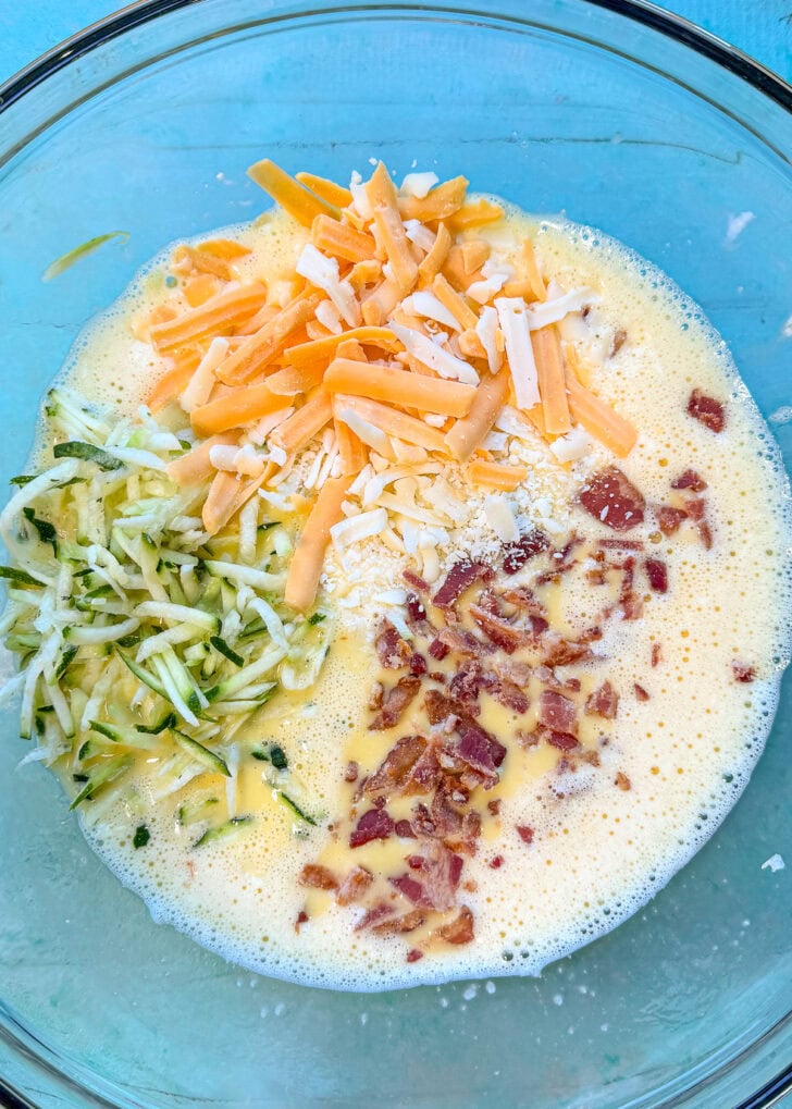eggs, cottage cheese, bacon, cheese, and zucchini in a glass bowl