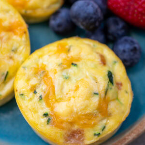 closeup of zucchini egg bites with cottage cheese beside fruit