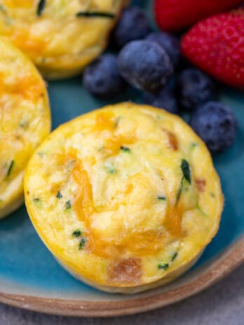 closeup of zucchini egg bites with cottage cheese beside fruit