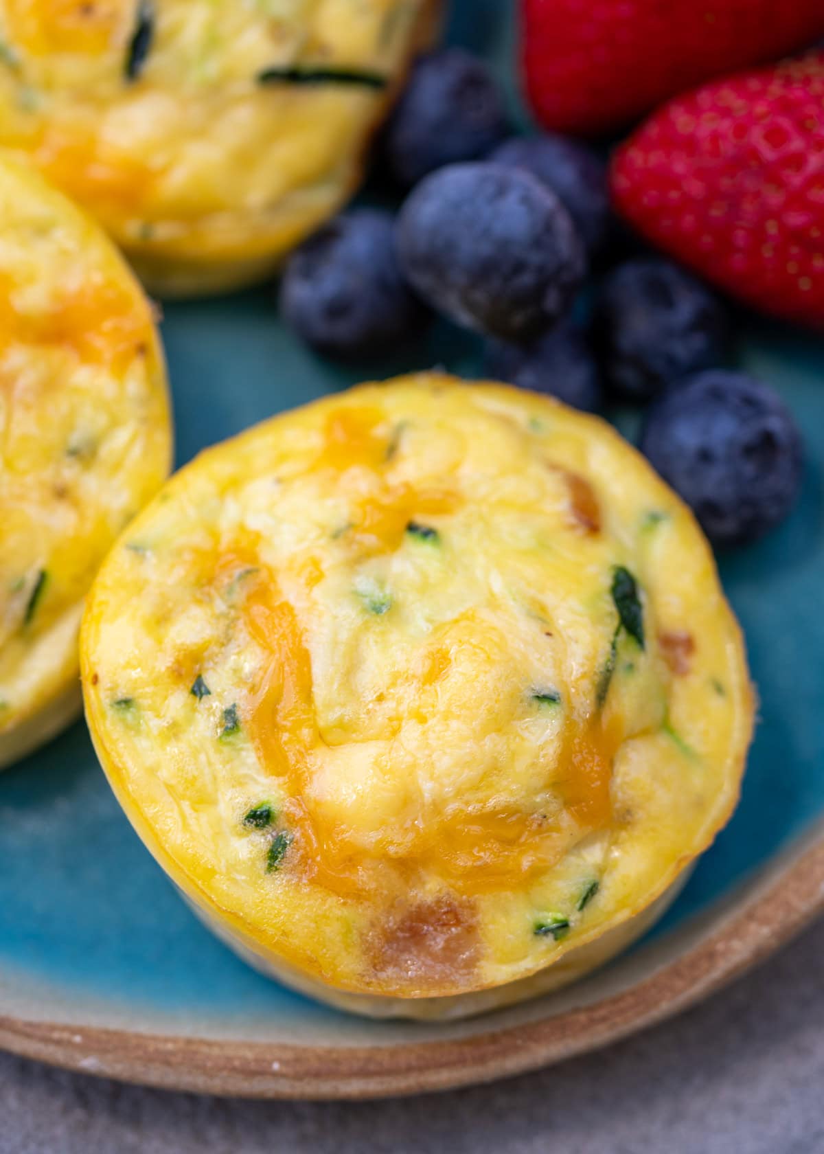 closeup of zucchini egg bites with cottage cheese beside fruit