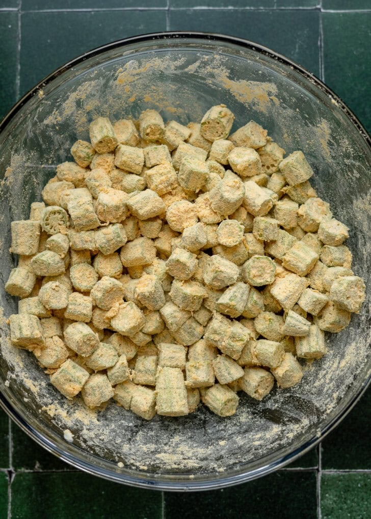 sliced okra covered in a dusting of seasonings and cornmeal