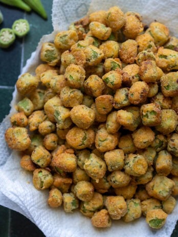 overhead shot showing golden brown pan fried okra in a bowl lined with paper towels