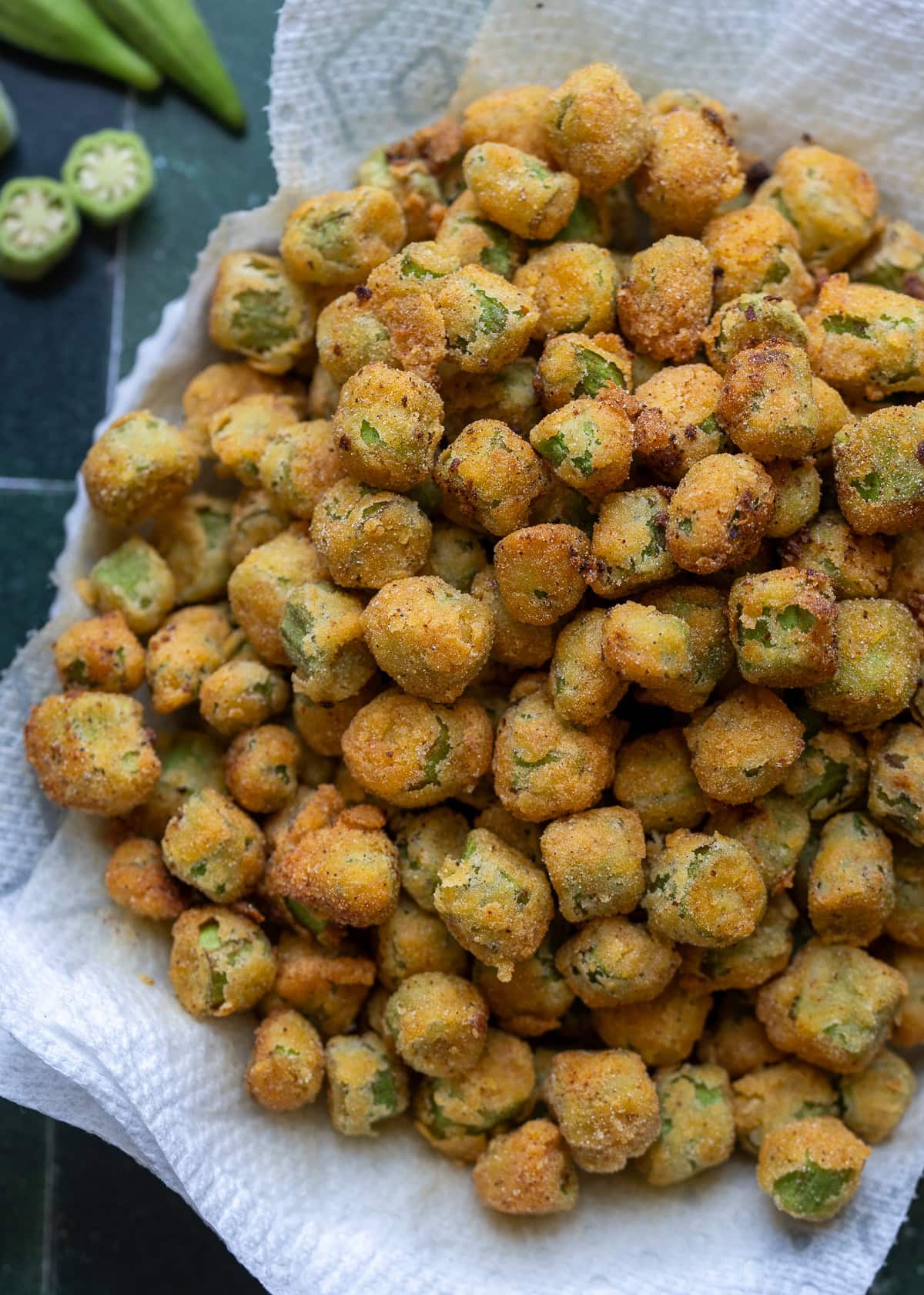 overhead shot showing golden brown pan fried okra in a bowl lined with paper towels