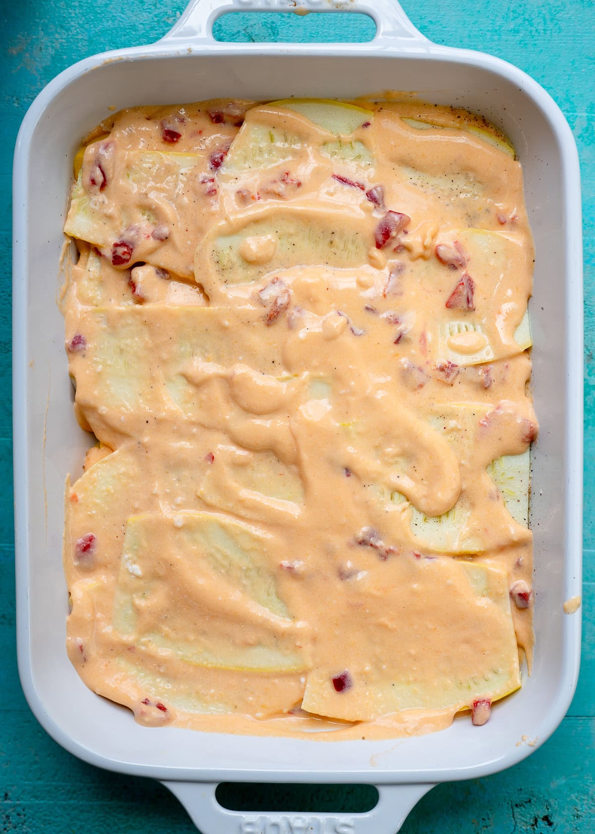 layers of summer squash and pimento cheese sauce in a casserole dish