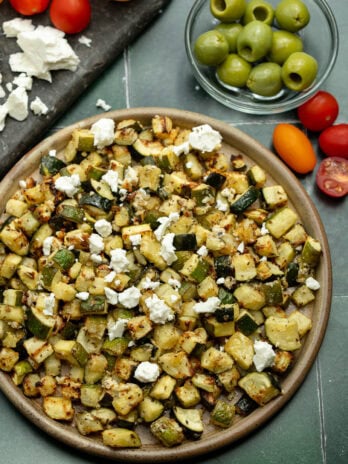 an overhead shot of zucchini cooked in the air fryer and garnished with feta