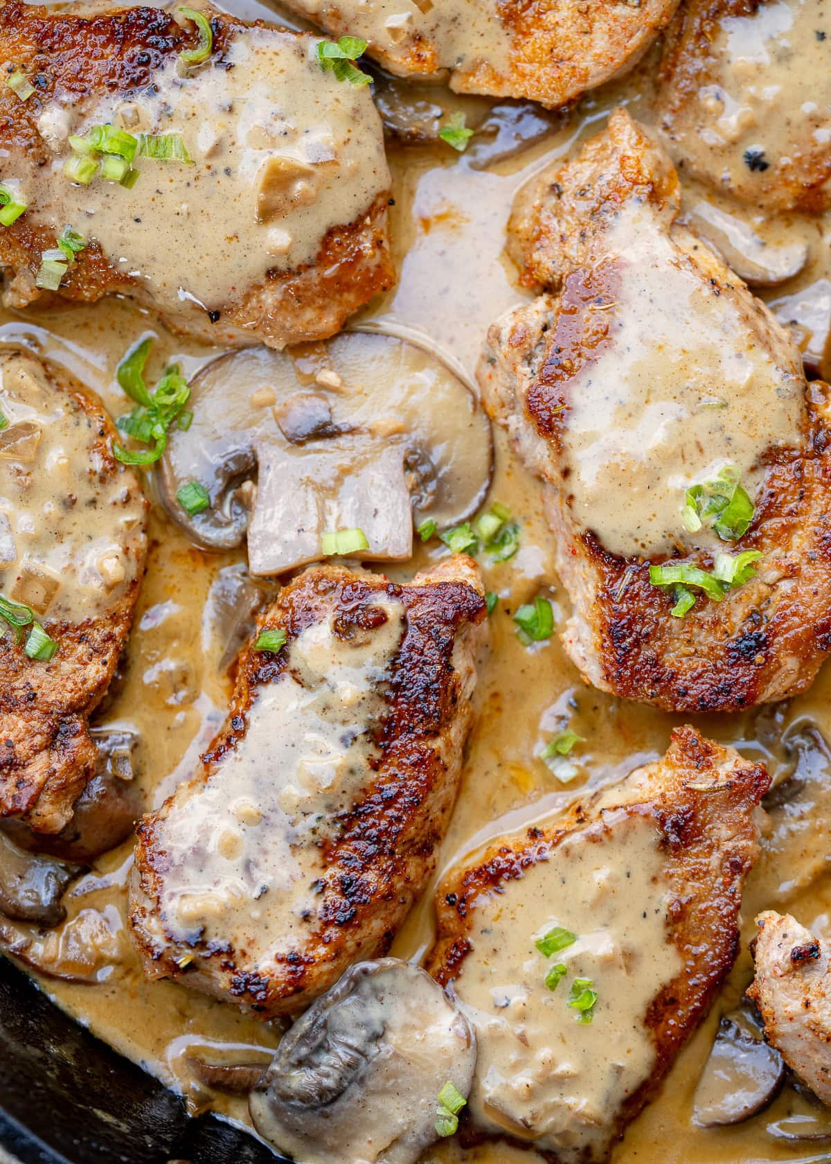 creamy mushroom gravy over juicy pork medallions in a cast iron skillet