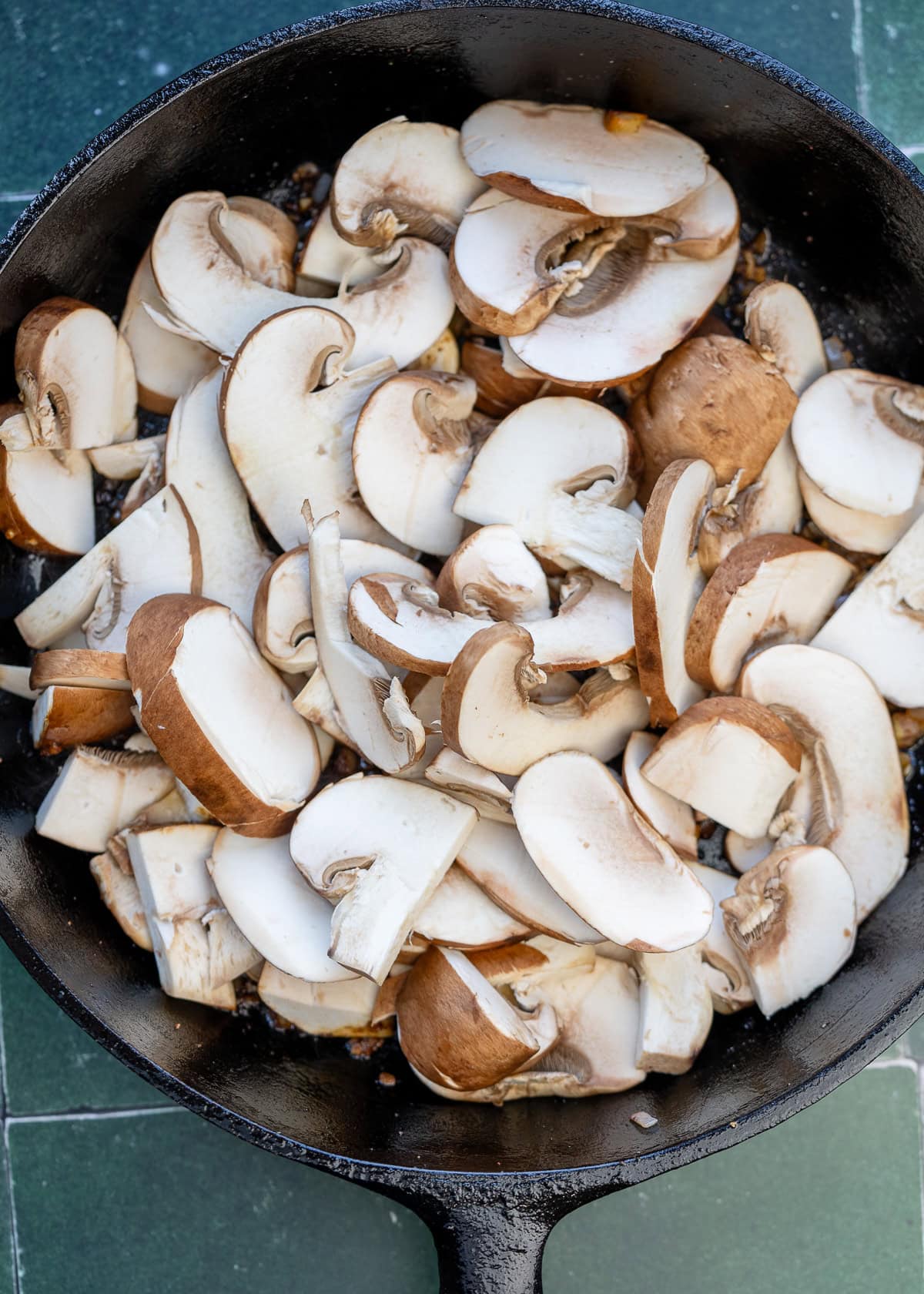 sliced mushrooms in a cast iron skillet