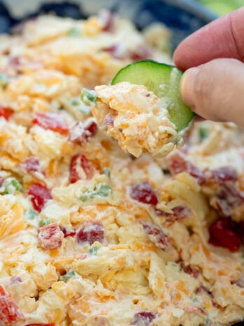 closeup to creamy pimento cheese dip on a sliced cucumber