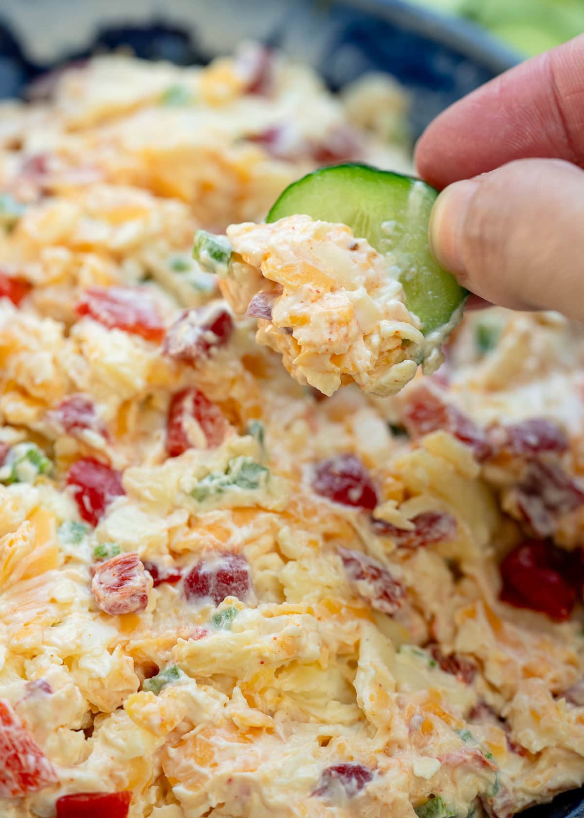 closeup to creamy pimento cheese dip on a sliced cucumber