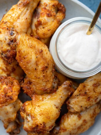 overhead shot showing crispy dry rub wings on a platter with dipping sauce