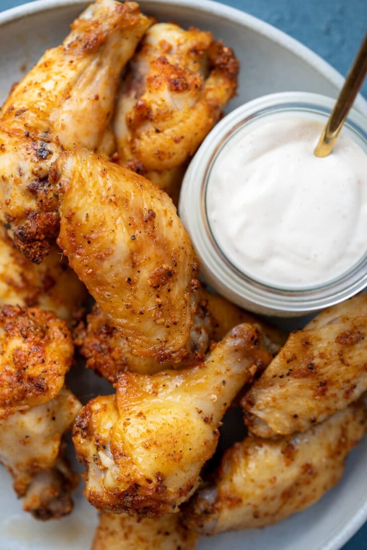 overhead shot showing crispy dry rub wings on a platter with dipping sauce