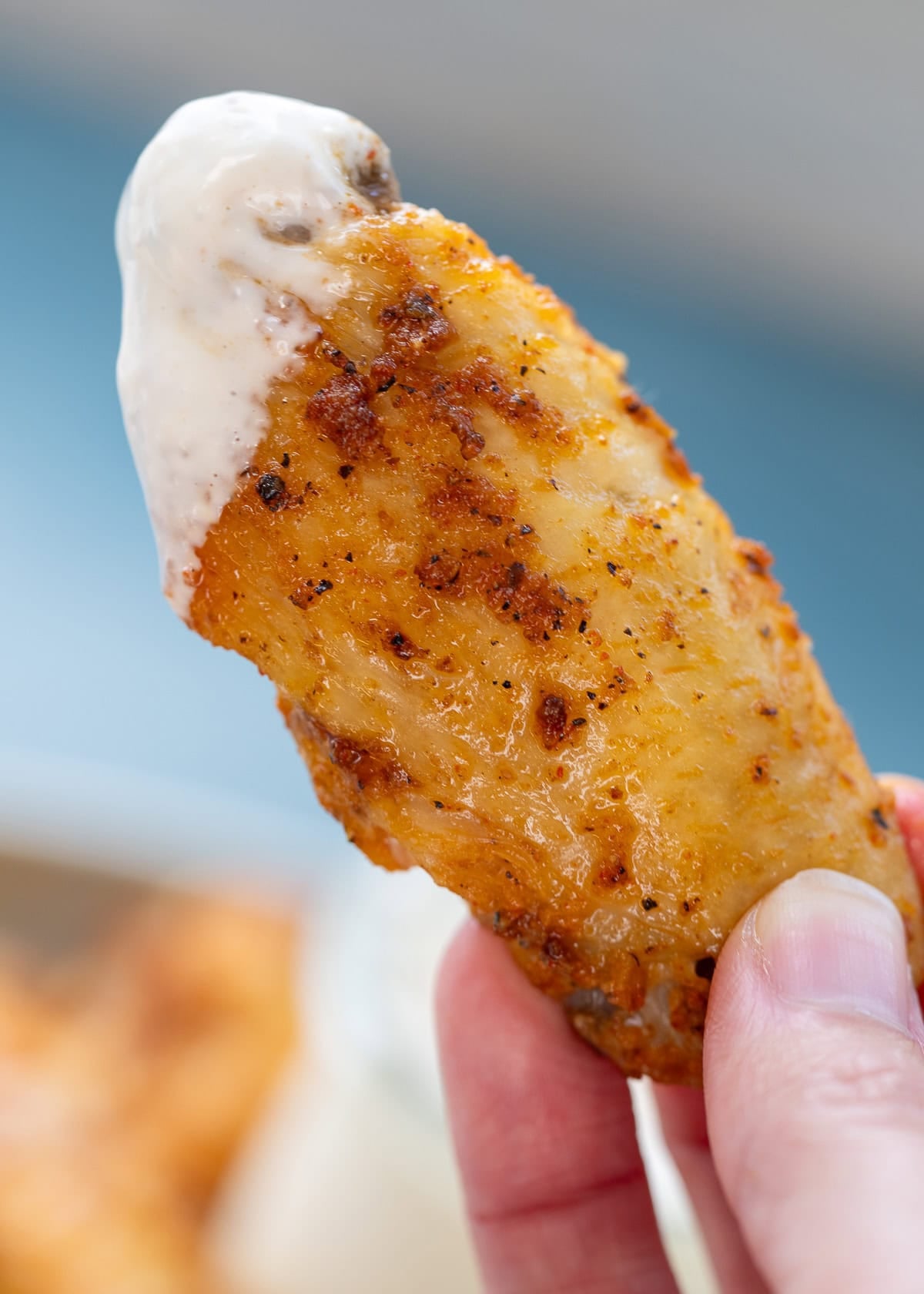perfectly crispy dry rub chicken wing dipped in alabama white sauce