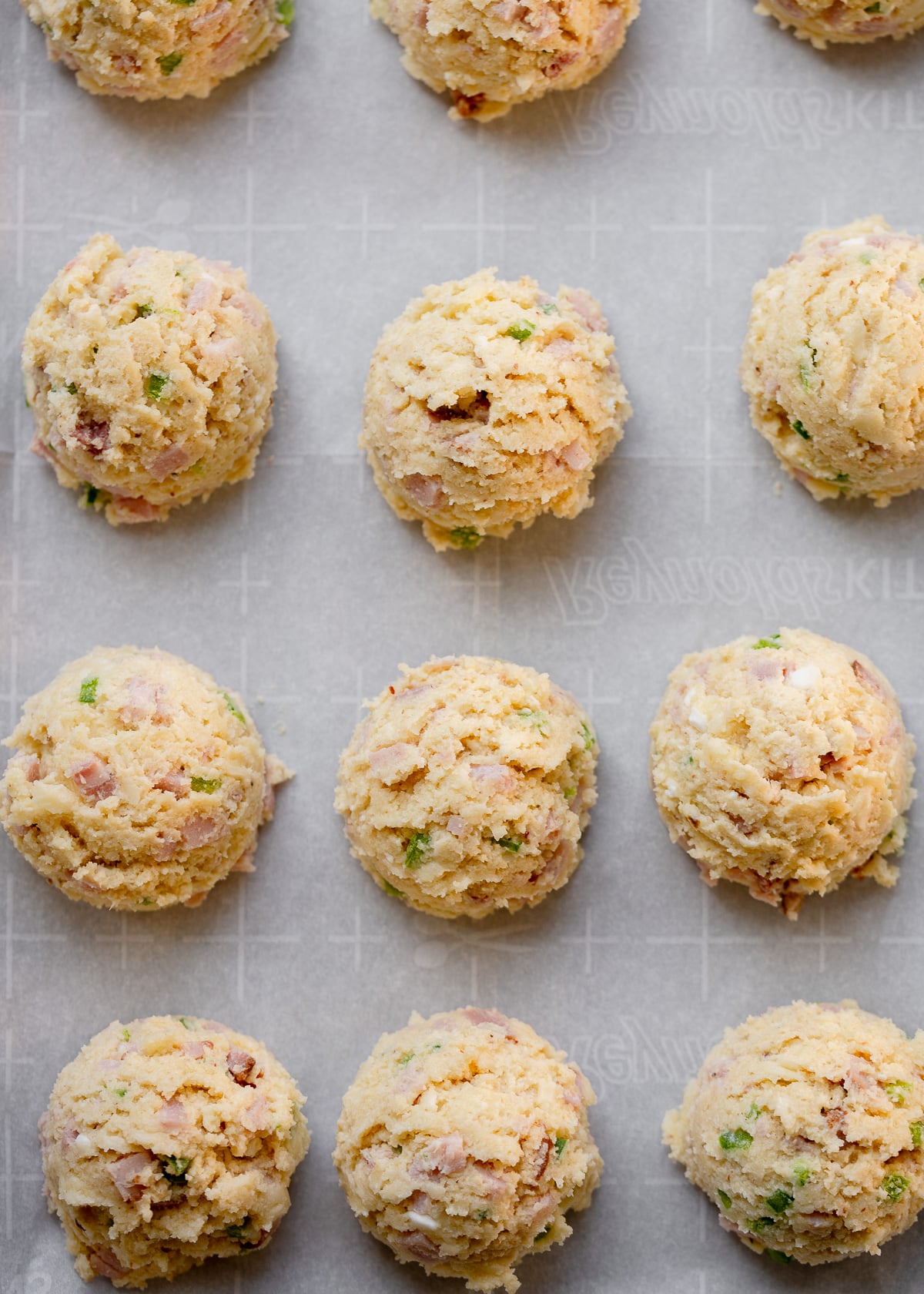 scoops of cottage cheese biscuit dough on a parchment paper lined pan