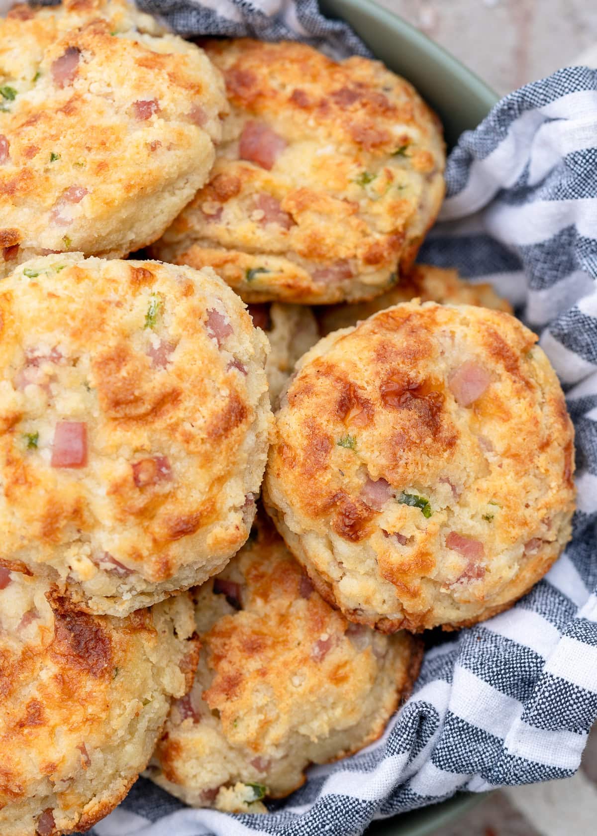 a basket full of cheesy gluten free muffins filled with cottage cheese, jam, and jalapeno