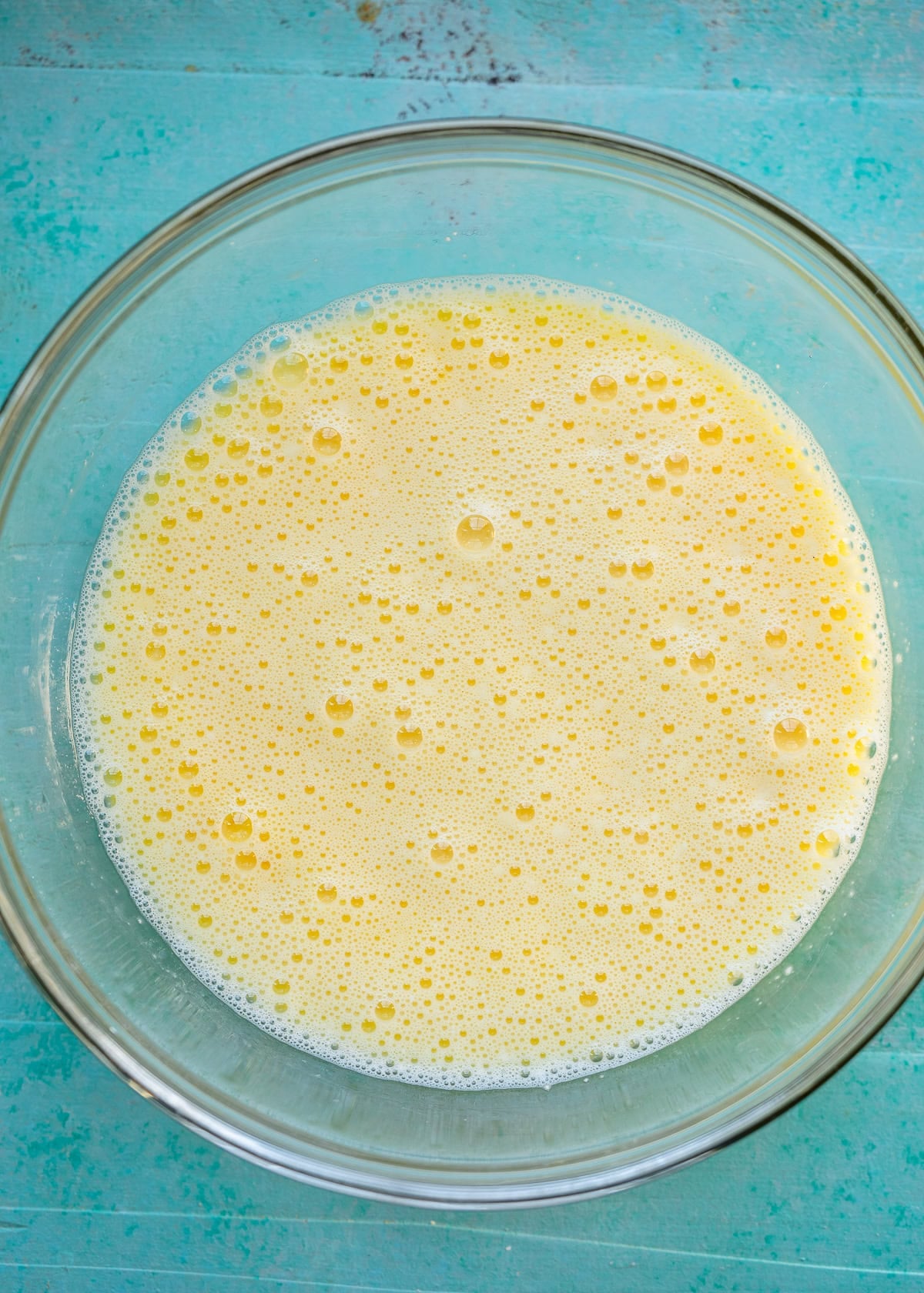 eggs whisked with cottage cheese in a glass bowl