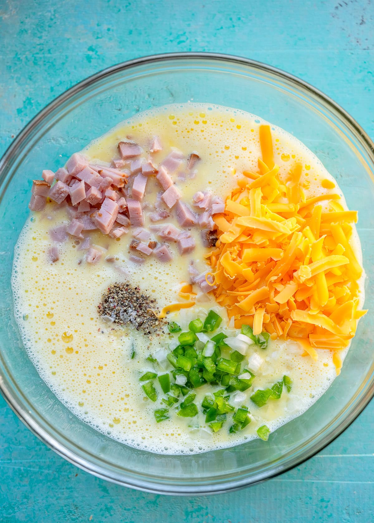 diced ham, shredded cheese, green bell pepper, onion, salt, and pepper in eggs and cottage cheese