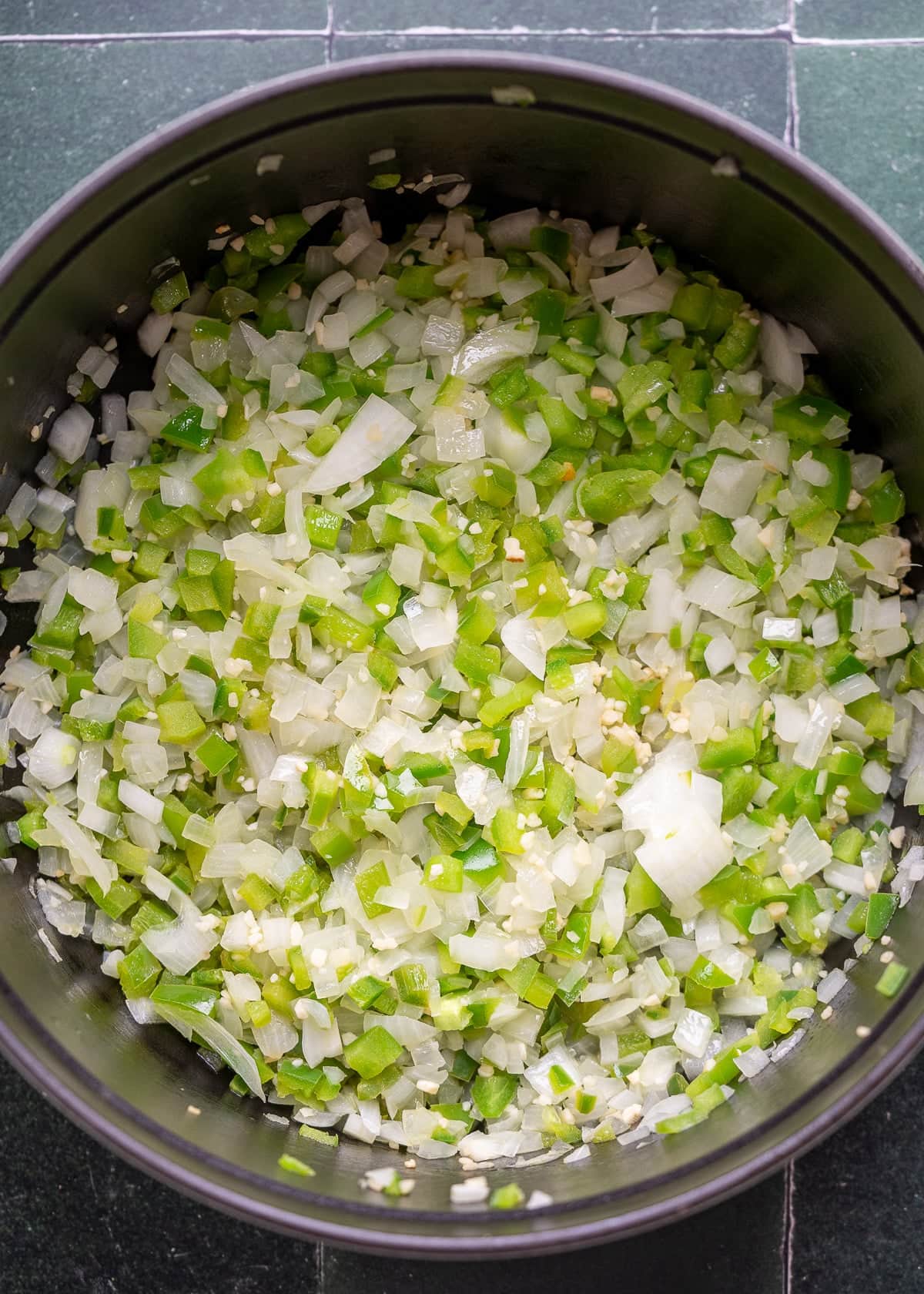 diced onion, bell pepper, jalapeno, and garlic in a large pot